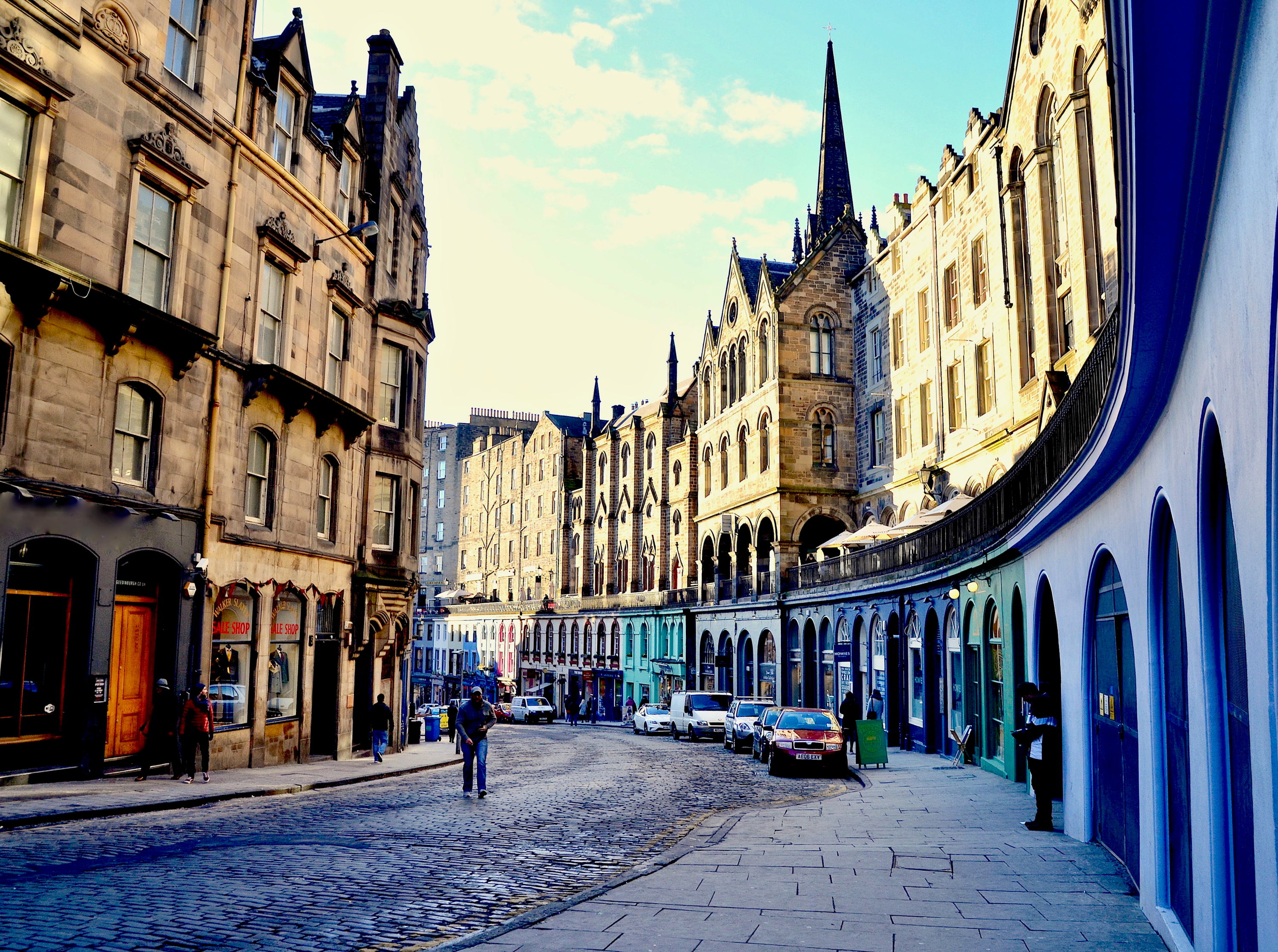 Man walking down cobbled Edinburgh street